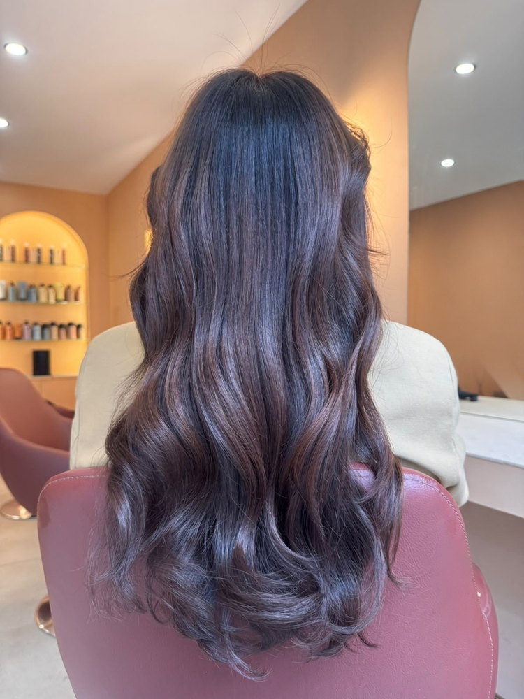 Brun profond aux reflets cuivrés, coiffage en boucles souples